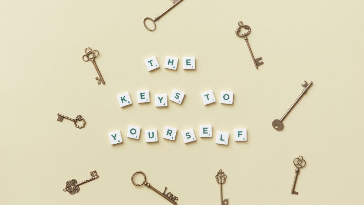 Motivational message with antique keys and letter blocks on yellow background.